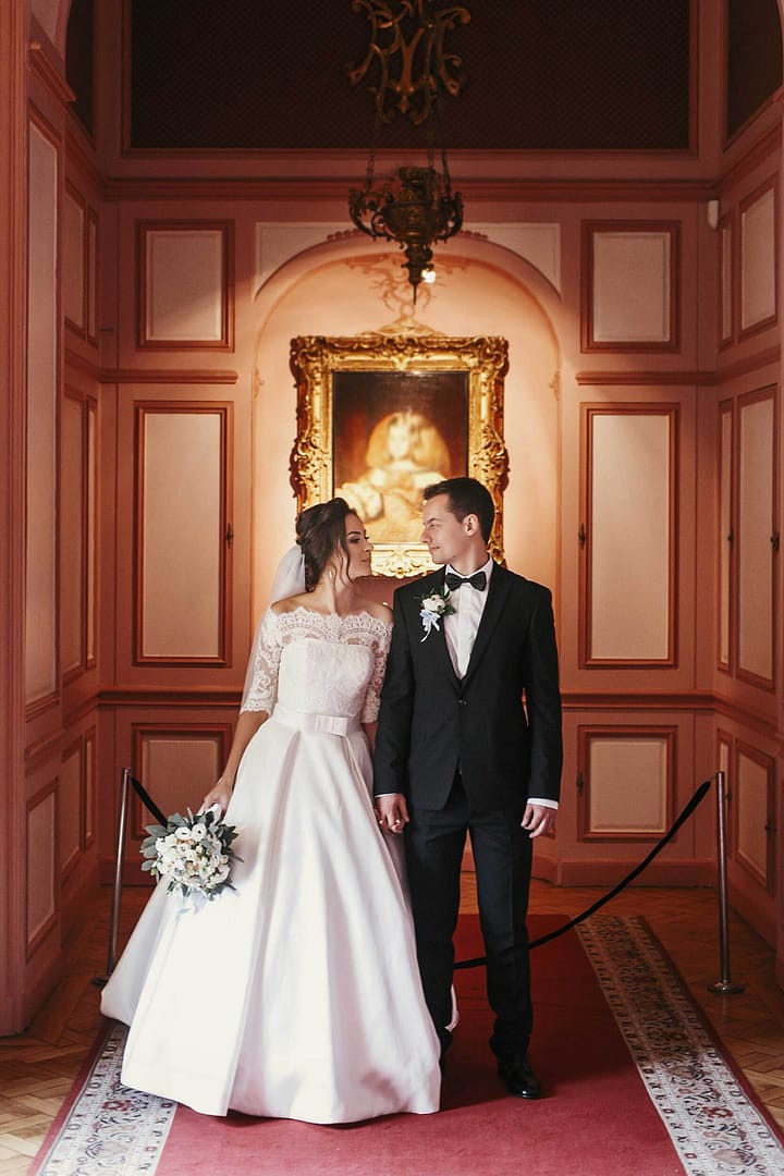 Bride in amazing dress with bouquet and stylish groom posing in
