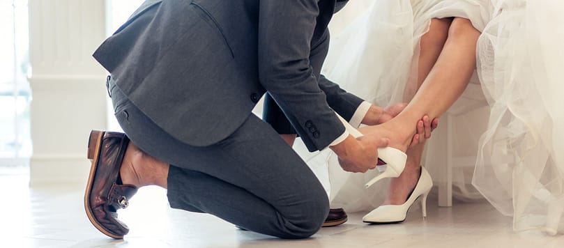 close-up-of-bride-trying-on-wedding-shoes-with-her-2023-11-27-05-03-54-utc