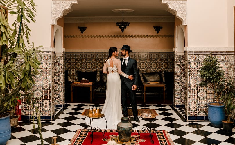 A couple dressed as brides in the interior of a Riad. Weeding concept