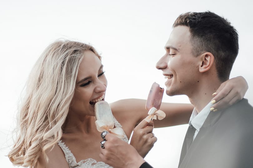 Happy authentic candid couple in love at VW cabriolet date in wedding dresses outdoor