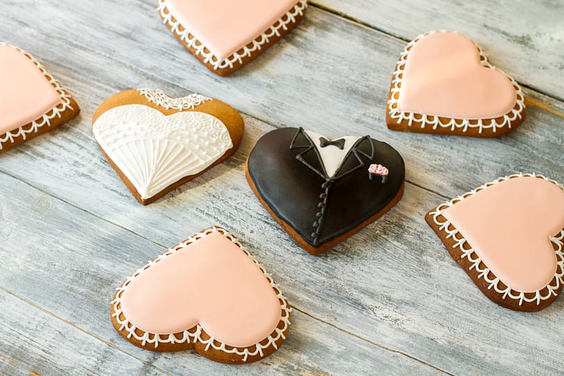 Wedding cookies on wooden background.