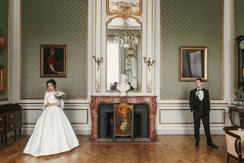 Bride in amazing dress with bouquet and stylish groom posing in