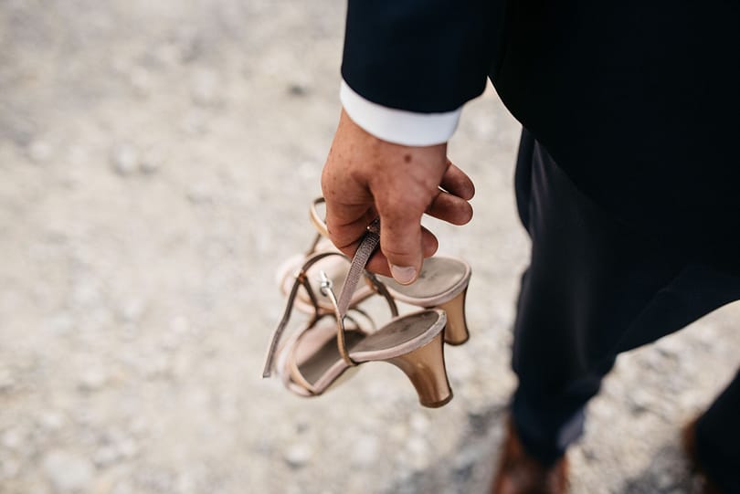 a-person-in-a-suit-holding-up-a-pair-of-shoes-2023-11-27-05-26-53-utc